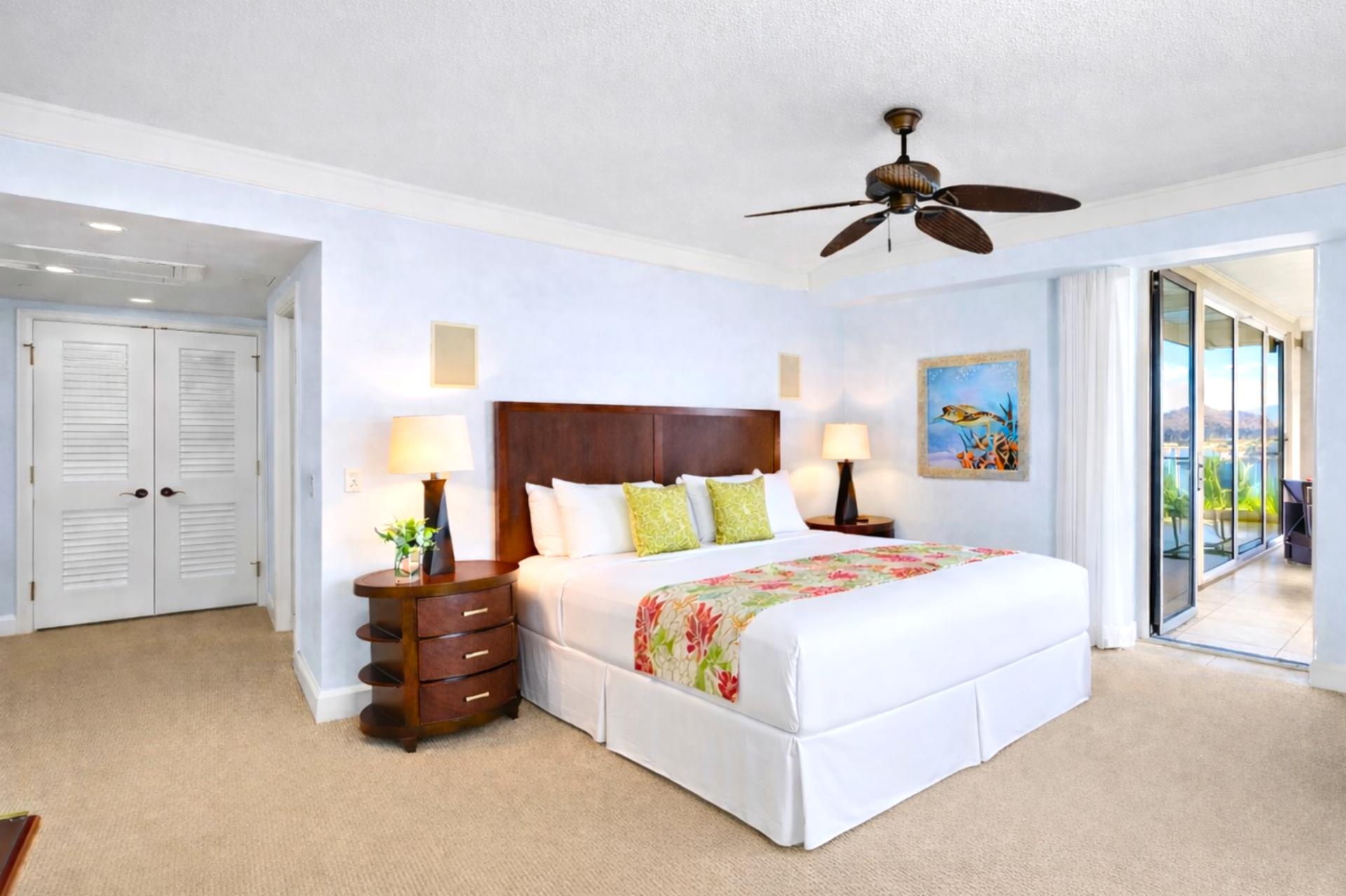 Primary suite with king bed, ocean-view terrace access, and calming coastal tones.