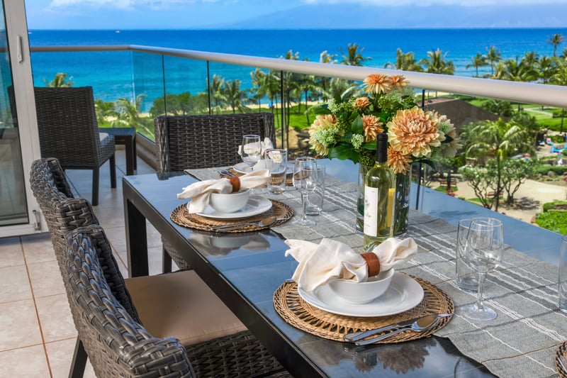 Elegant oceanside dining with wine, flowers, sunshine, and tropical views.