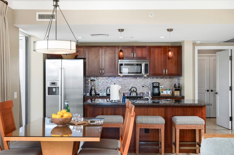Modern kitchen with island seating, stainless appliances, and tropical elegance. HKH-609