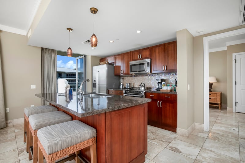 Bright gourmet kitchen with granite island, rich wood cabinets, coastal luxury. HKH-609