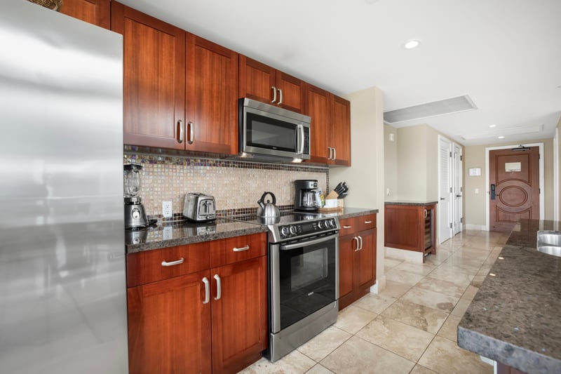 Fully-equipped kitchen with sleek appliances, espresso cabinetry, and luxury finishes. HKH-609