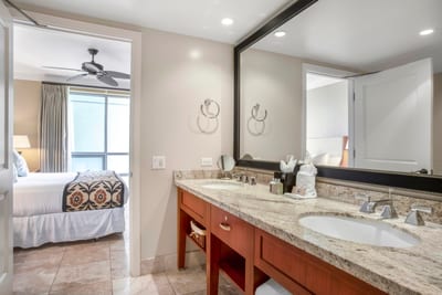 Elegant bathroom with granite counters, double sinks, and tropical comfort nearby.
