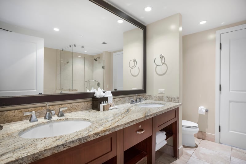 Spa-style bathroom with glass shower, granite countertops, and elegant lighting. HKH-609