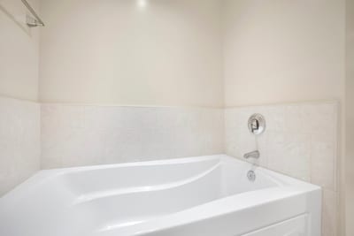 Soak and unwind in deep tub with serene, minimalist design.