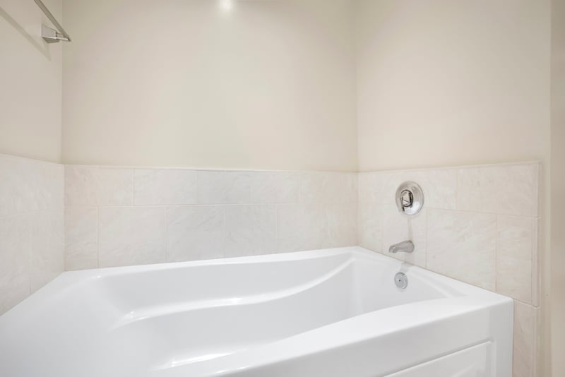 Soak and unwind in deep tub with serene, minimalist design.