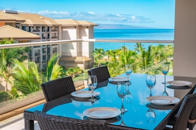 Elegant lanai dining with ocean views and tropical island breeze.