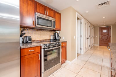 Sleek island kitchen with modern appliances and welcoming entry hallway.
