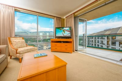 Bright island living room with mountain views and balcony access.
