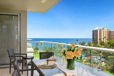 Elegant oceanview dining with tropical flowers and serene blue horizon.