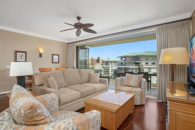 Cozy, sunlit living room opens to beautiful balcony views.
