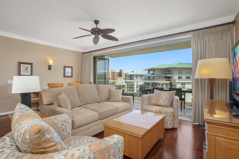 Cozy, sunlit living room opens to beautiful balcony views.