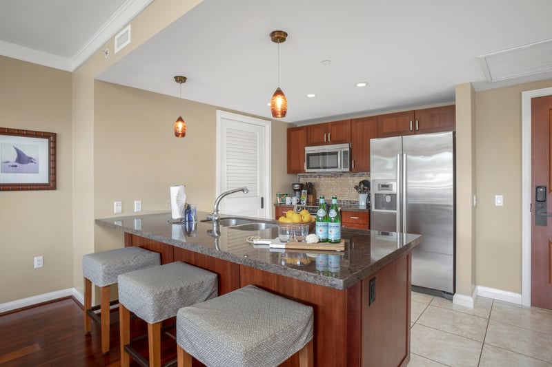 Sleek open-concept kitchen with granite counters and mosaic backsplash.