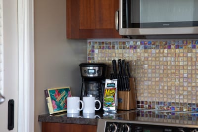 Morning essentials: Maui coffee, mugs, chocolates, and polished kitchen backdrop.