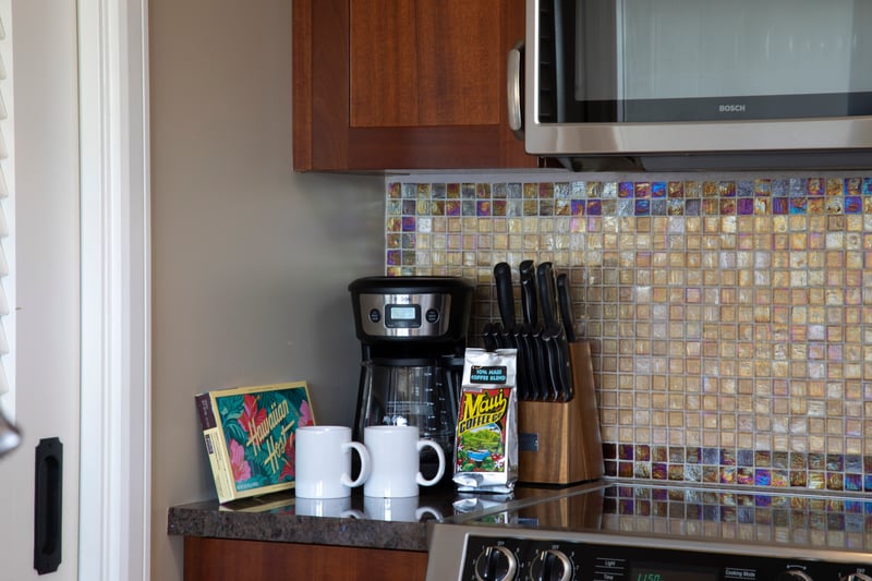 Morning essentials: Maui coffee, mugs, chocolates, and polished kitchen backdrop.