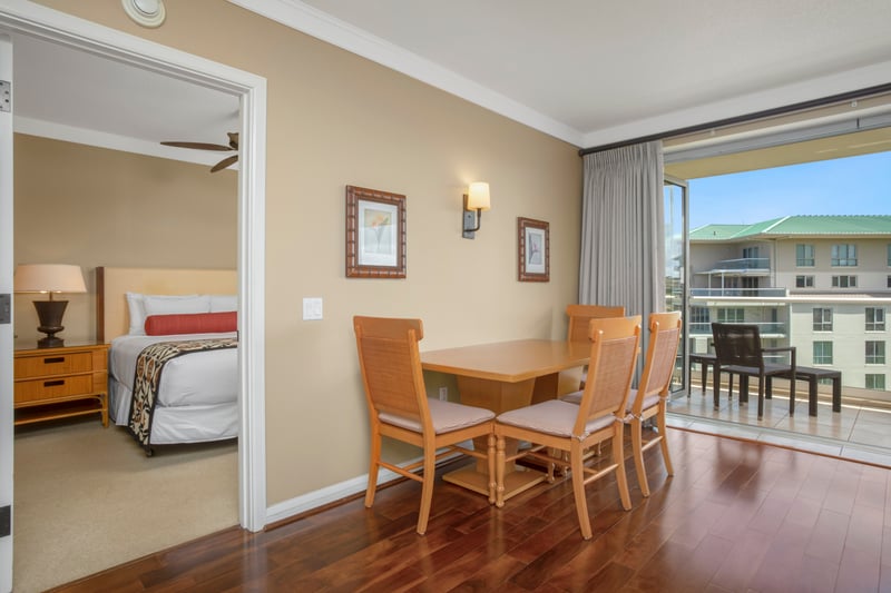Bright dining space beside balcony, steps from cozy bedroom retreat.