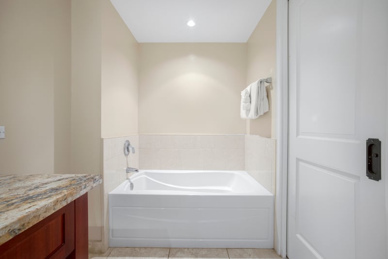 Serene soaking tub with granite accents and soft wall lighting.