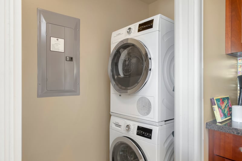 Compact laundry nook with stacked Bosch washer and dryer units.