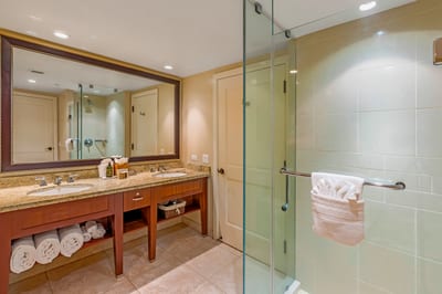 Unwind in a spa-style bathroom with dual vanities, glass walk-in shower, and sleek resort-quality finishes