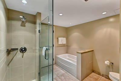 Refresh in this sleek bathroom escape with glass shower, double vanities, and soft resort lighting