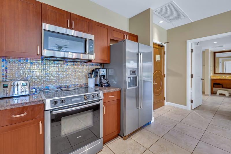 Modern kitchen with mosaic backsplash and sleek stainless steel appliances.