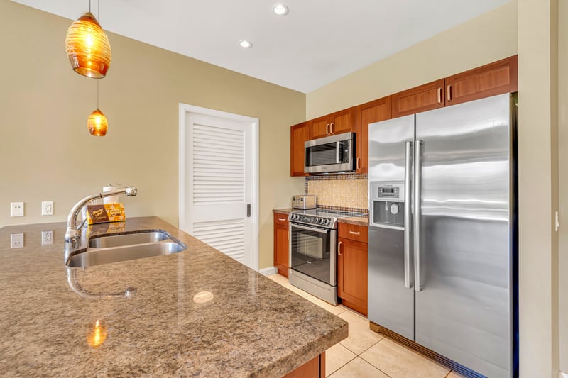 Granite countertops and stainless steel appliances in gourmet kitchen space.