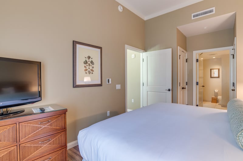 Cozy bedroom with ensuite bath, warm tones, and modern amenities.