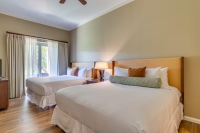 Bright double-bed room with balcony access and cozy modern decor.