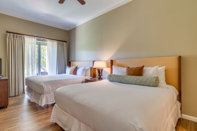 Bright double-bed room with balcony access and cozy modern decor.