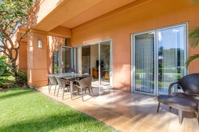 Private patio with sliding doors, outdoor dining, and garden serenity.