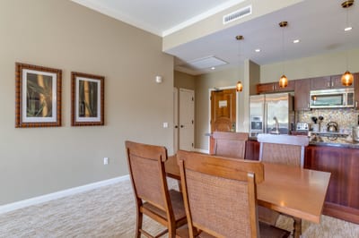Stylish dining area beside modern kitchen with pendant lighting accents.