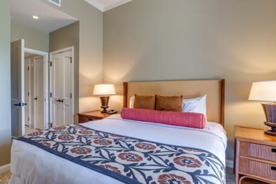 Cozy bedroom features elegant lighting, floral accents, and warm tones.