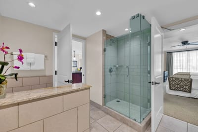 Glass-walled shower and updated finishes brig resort polish to this guest bathroom