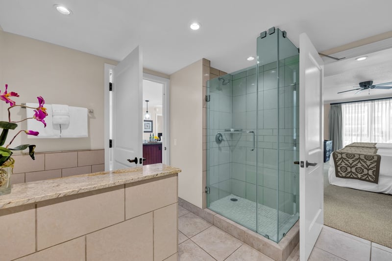 Glass-walled shower and updated finishes brig resort polish to this guest bathroom
