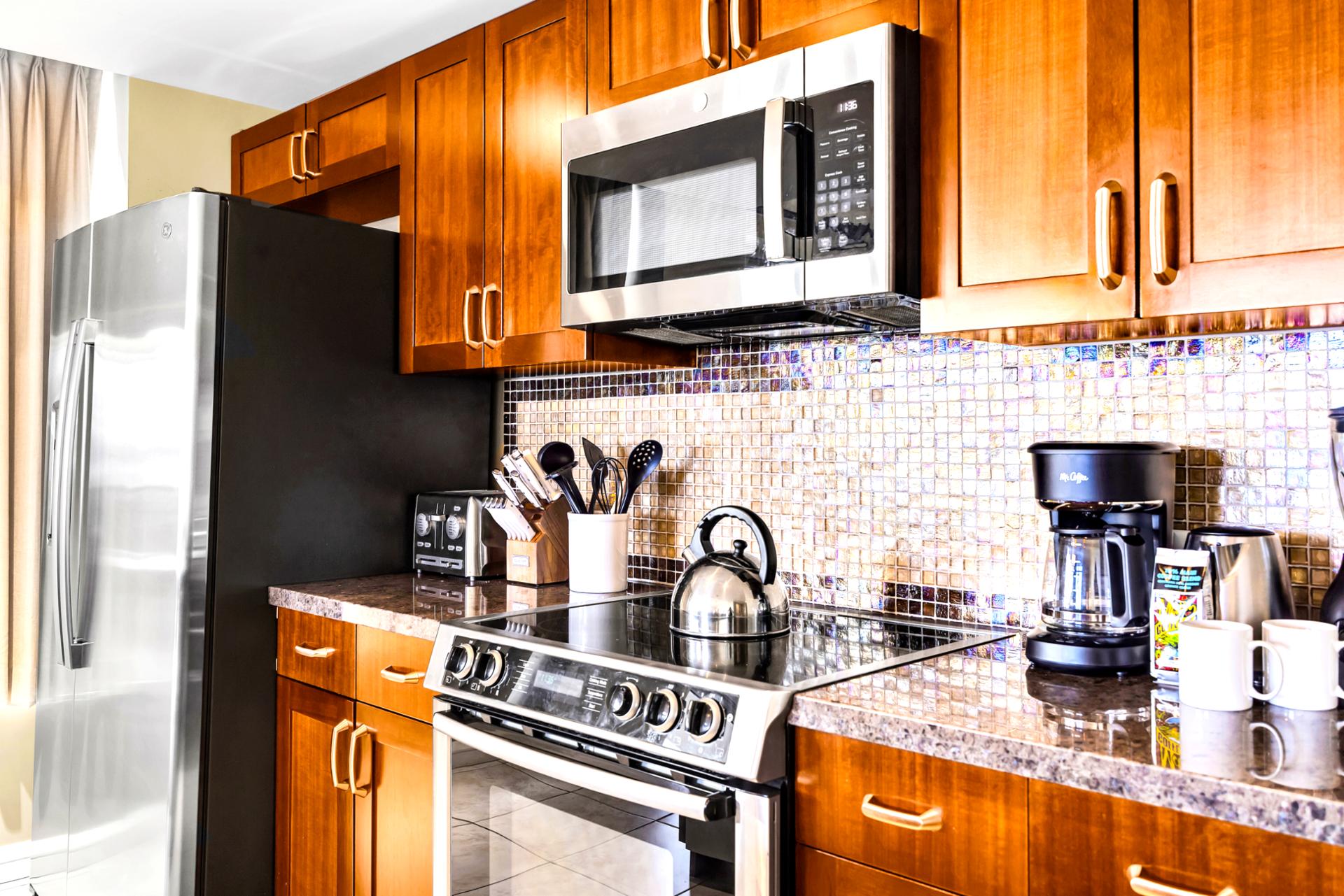 Prep and plate on granite counters with rich cabinetry, a polished space that makes even quick lunches feel upgraded.