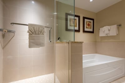 Elegant bathroom with walk-in shower, soaking tub, and decorative towels. HKK-225
