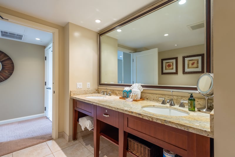 Spacious bathroom with dual sinks, granite counters, and warm lighting. HKK-225