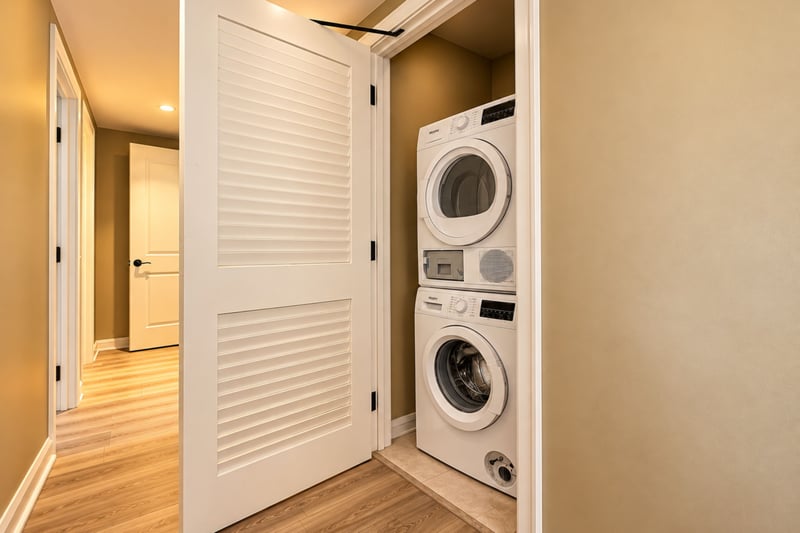 An in-residence stacked washer and dryer sits in a hallway closet, handy for refreshing beachwear and packing lighter. HKK-229