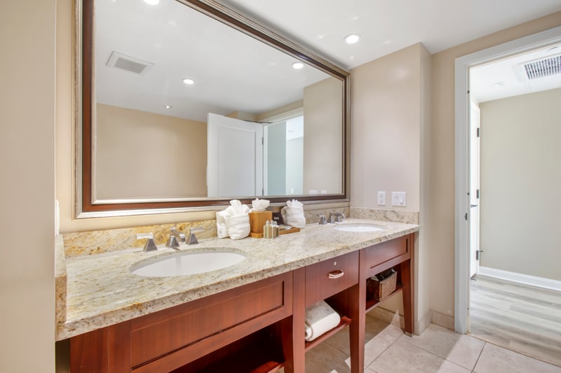 Spacious dual-sink vanity with granite elegance and soft lighting.