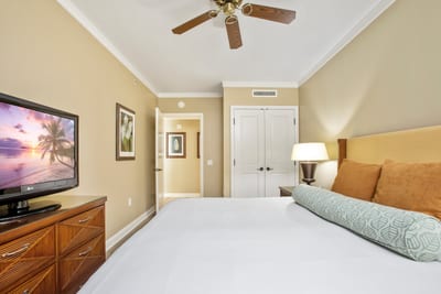 Elegant tropical bedroom with warm tones, ceiling fan, and comfort.