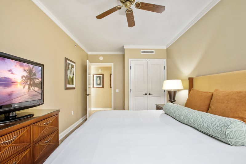 Elegant tropical bedroom with warm tones, ceiling fan, and comfort.