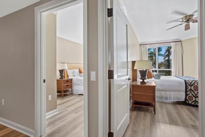 Two serene bedrooms with palm views and inviting island elegance.