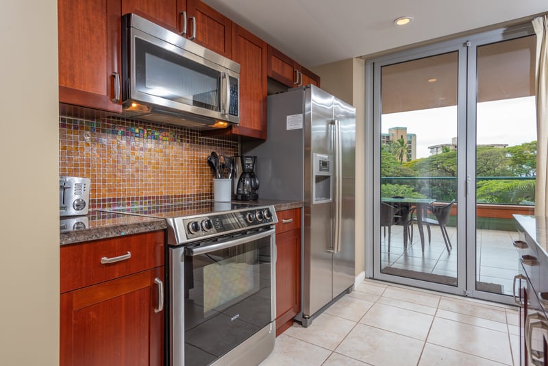 Sleek kitchen with mosaic backsplash and access to outdoor dining