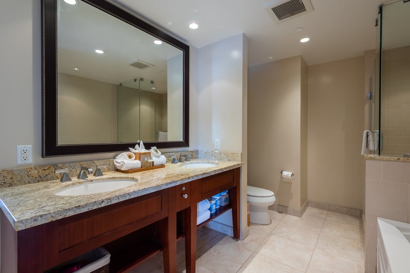 Spacious bathroom with granite double vanity and modern glass shower for easy mornings