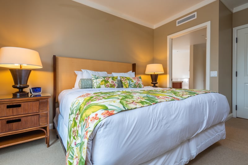 Plush king bed with tropical decor and soft ambient lighting