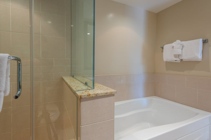 Inviting soaking tub for at-home spa vibes and spacious walk-in shower for quick refreshes