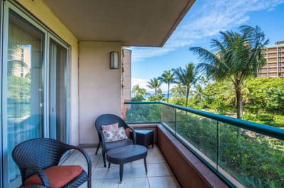 Cozy lanai seating with ocean breeze and tropical garden views.