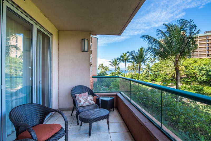 Cozy lanai seating with ocean breeze and tropical garden views.
