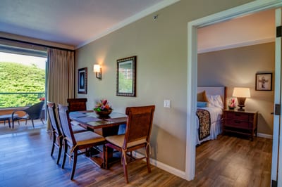 Elegant dining area and cozy bedroom with tropical garden views.