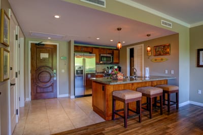 Inviting entryway leads to modern kitchen with island bar seating.