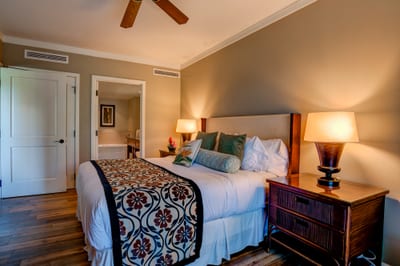 Warm lighting and tropical décor create a serene bedroom escape.